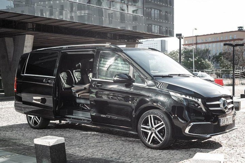A black Mercedes-Benz SUV parked in an urban setting with a modern building in the background. 3