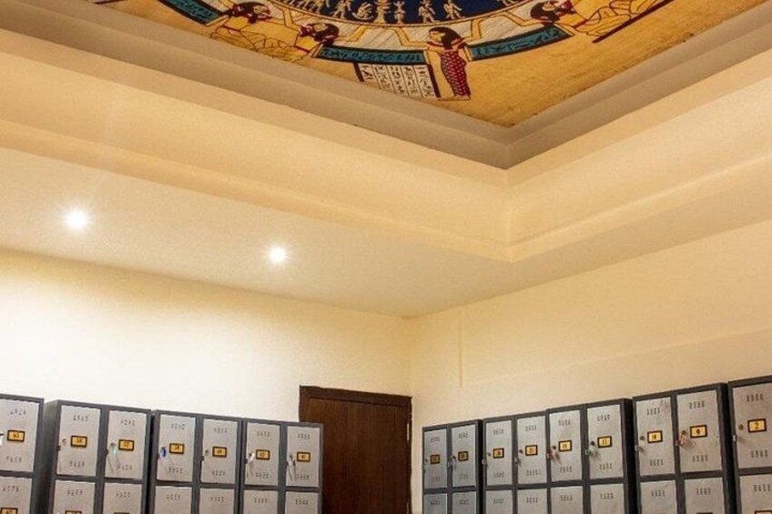 A room with a high ceiling, a wooden door, and multiple filing cabinets. 2