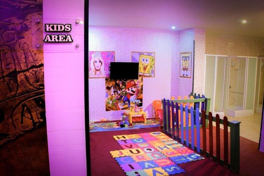 A children's play area with a colorful floor, a playpen, and cartoon character decorations. 3