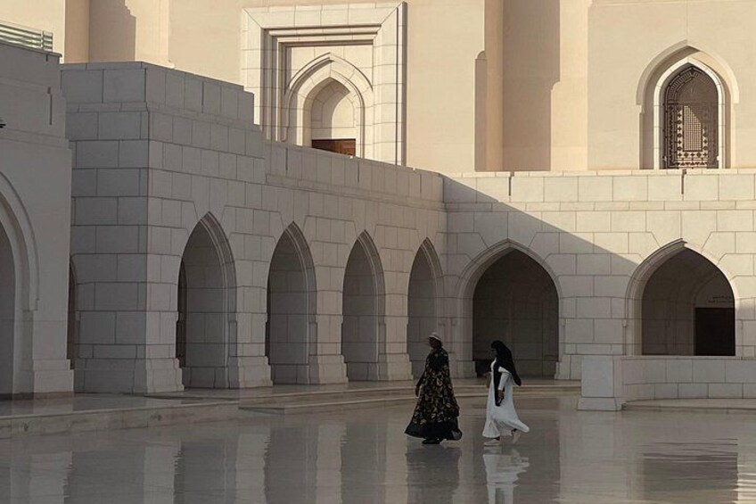 A courtyard with arches and a reflective floor. 2