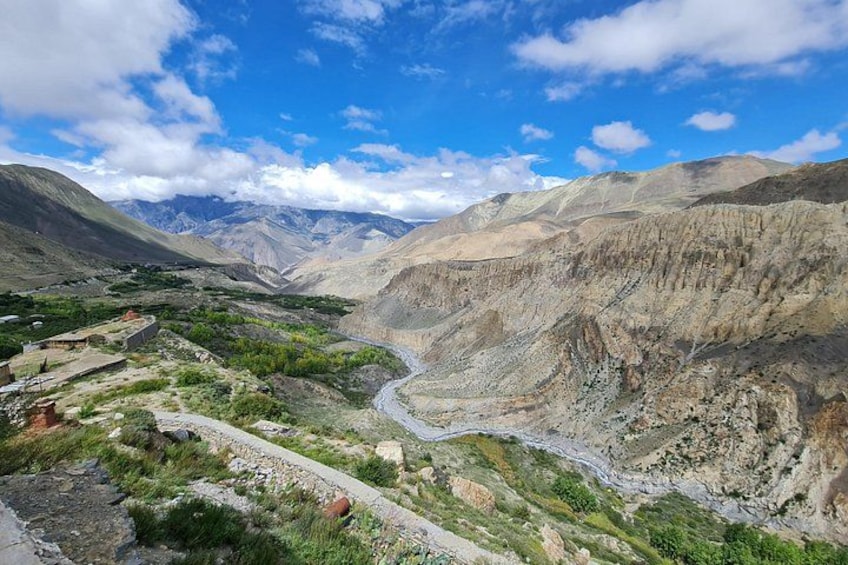 A mountainous landscape with a winding river, rocky terrain, and sparse vegetation. 4