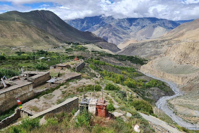 A mountainous landscape with a winding river, terraced fields, and traditional buildings. 3