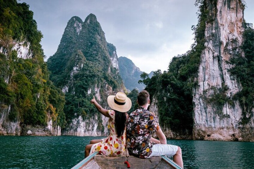 Deux personnes se trouvent sur un bateau, face à un paysage montagneux avec une étendue d’eau. 4