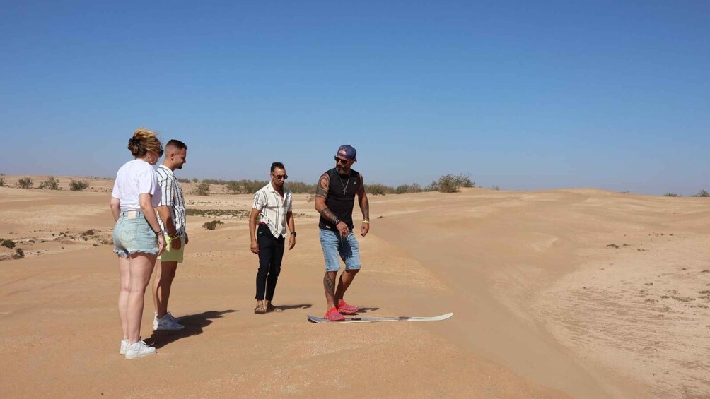 A group of people standing on a desert road with a clear sky. 5