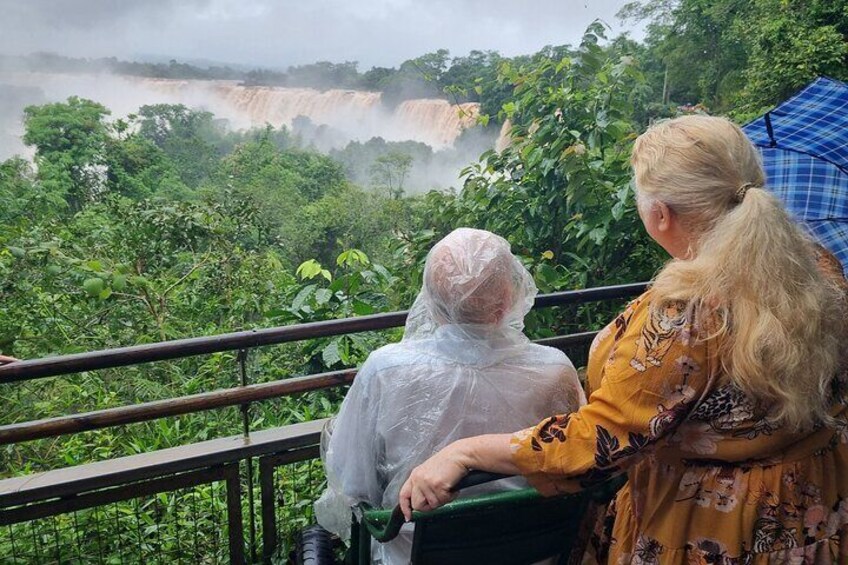 Dos personas contemplando una cascada desde una barandilla. 2