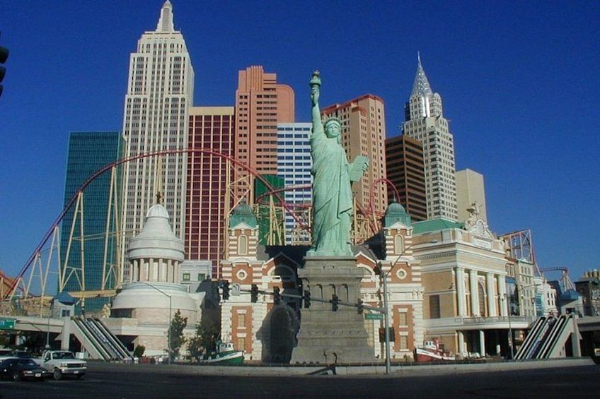 Un paysage urbain avec une statue imposante, des montagnes russes et des bâtiments modernes. 2