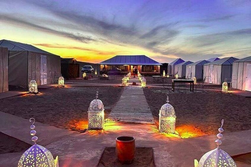 A campsite with tents, lanterns, and a pathway leading to a central structure. 3