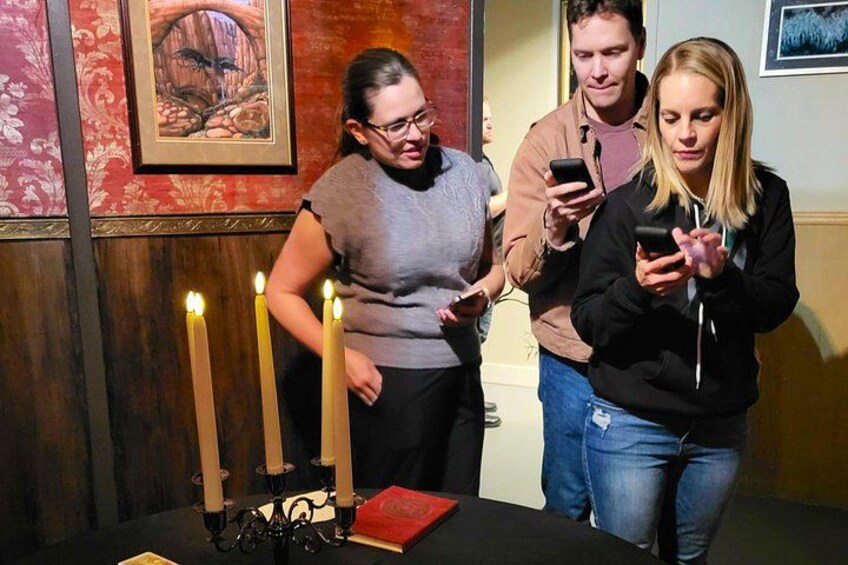 Un grupo de personas de pie cerca de una mesa con velas encendidas y un libro. 2