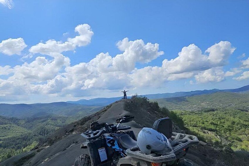 A motorcycle parked on a mountain road with a scenic view of the landscape. 2