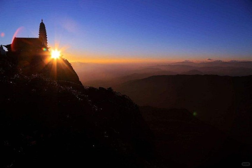 A mountain landscape with a temple silhouette against a sunset. 4