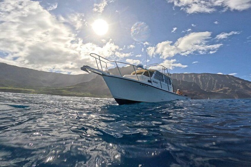 A boat on calm water with mountains in the background. 2