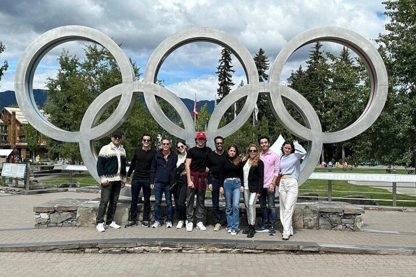 Un grupo de personas posando frente a los anillos olímpicos. 3