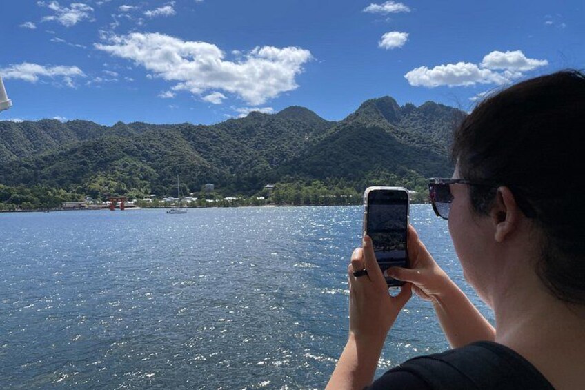 A person taking a photo of a lake with mountains in the background. 5