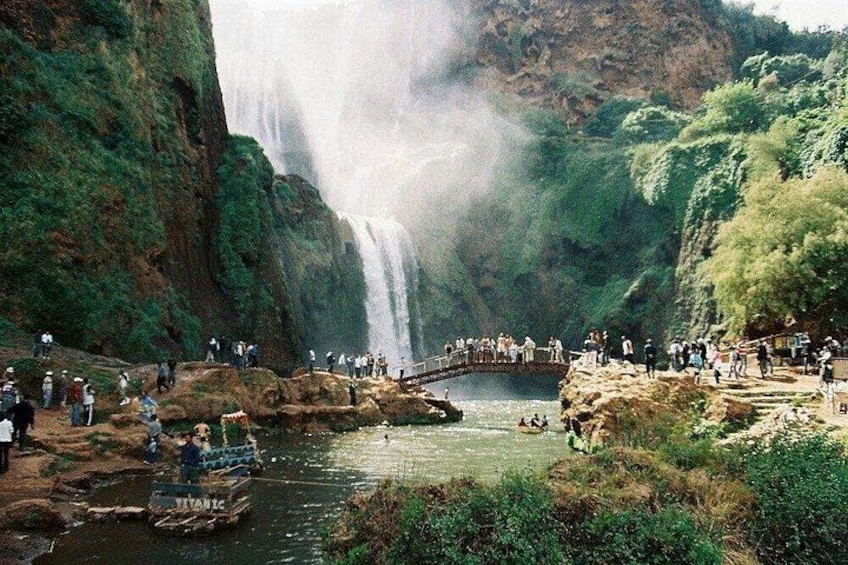 Een waterval, een brug en mensen die het uitzicht bewonderen. 3