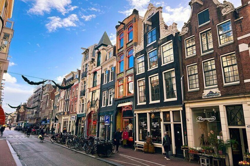 A street lined with colorful buildings, bicycles parked along the sidewalk, and a clear blue sky. 2