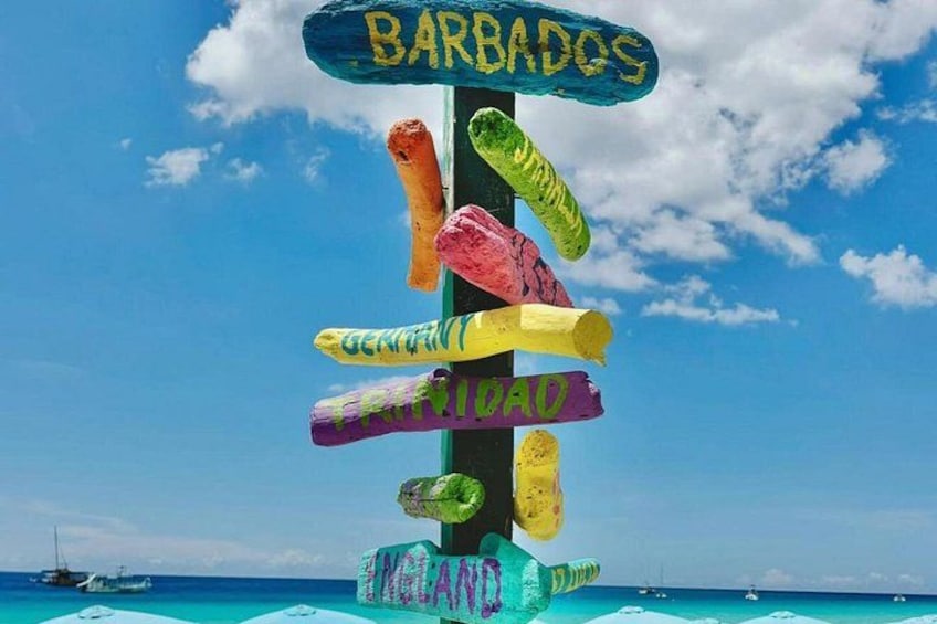 A colorful signpost with destinations like Barbados and Panama. 1