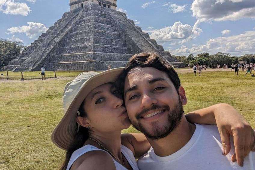 Una gran estructura piramidal con turistas al fondo. 1