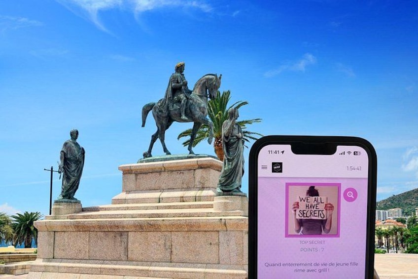 Un teléfono inteligente muestra la portada de un libro con una estatua de un jinete al fondo. 1