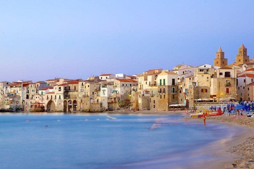 A coastal town with historic buildings, a beach, and a tower. 5