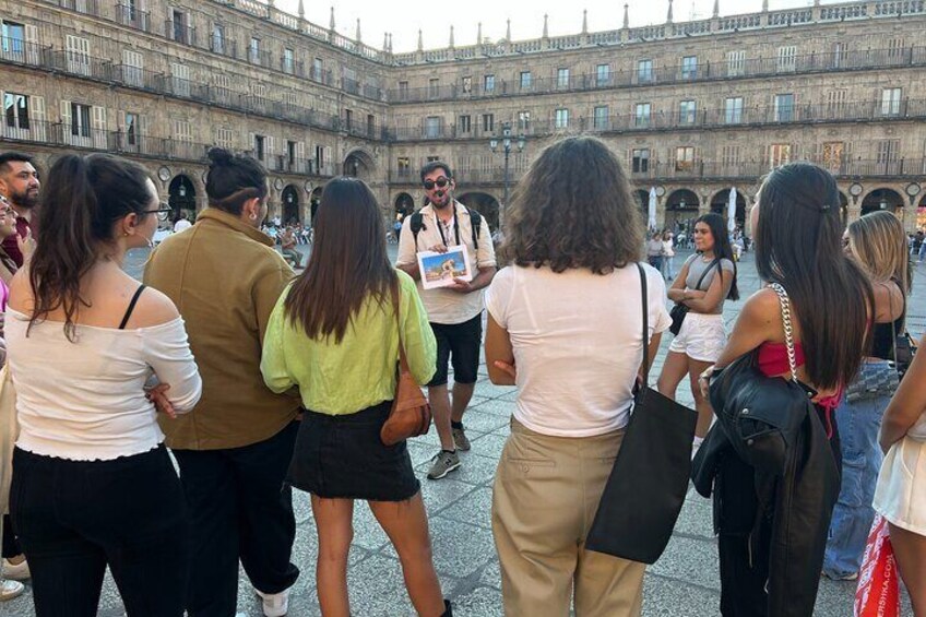A group of people standing in a courtyard with a historic building in the background. 5
