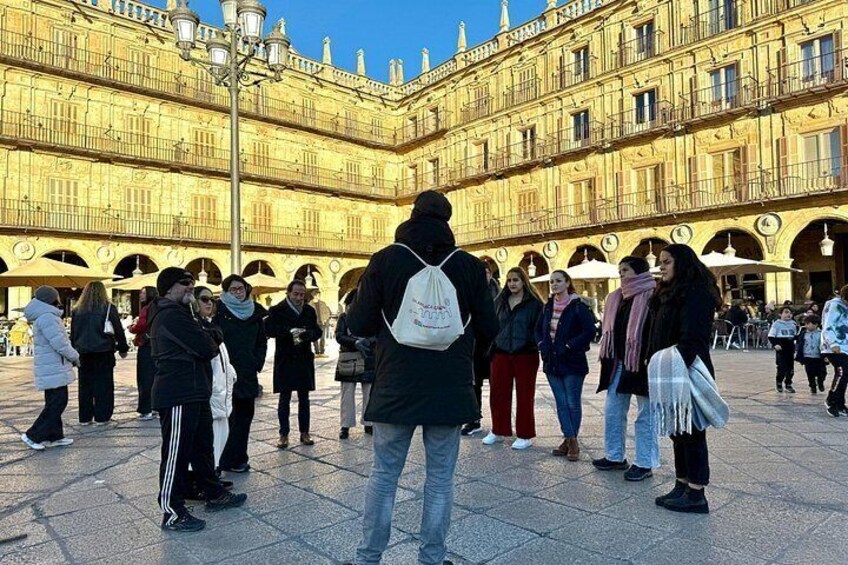 A historic building with multiple arches and a crowd of people in front. 3