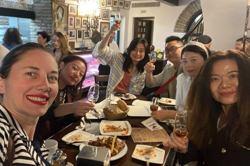 A group of people dining at a restaurant with plates of food and drinks. 2