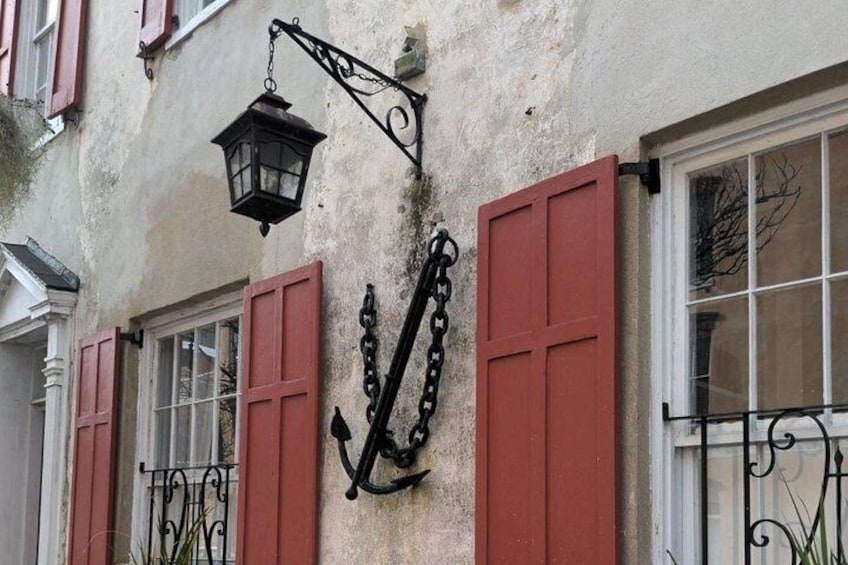 A building with red shutters, a hanging lantern, and a wrought iron gate. 3