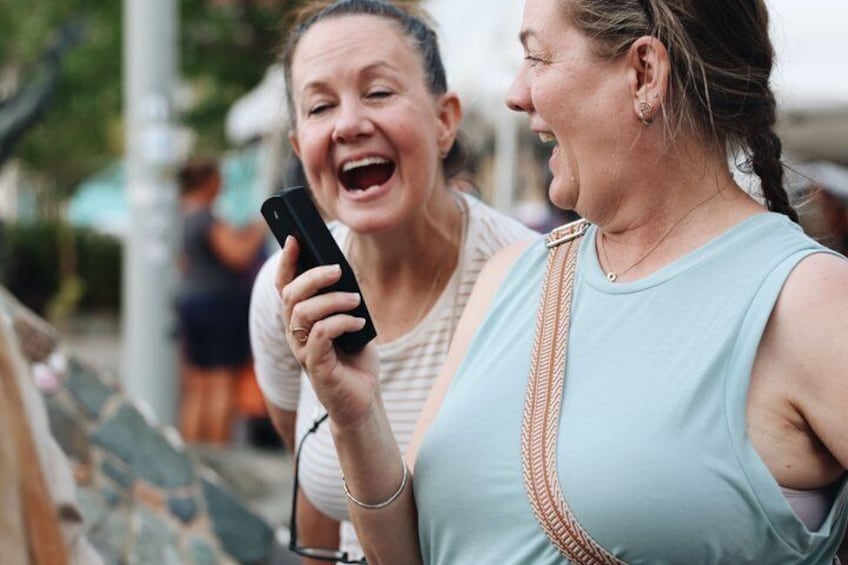Two people standing outdoors, one holding a smartphone. 2