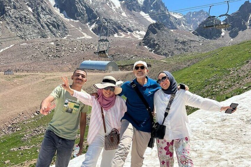 A group of people taking a selfie on a mountain trail with a ski lift in the background. 4
