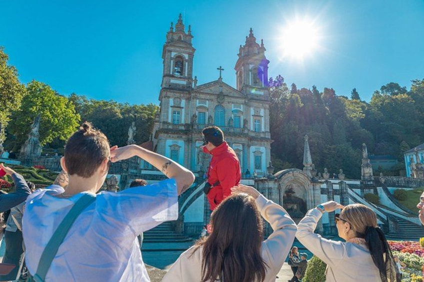 A group of people taking photos in front of a historic building with a bell tower. 2