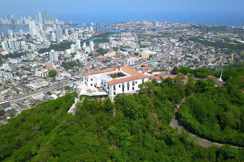 A coastal cityscape with a prominent white building surrounded by greenery. 3