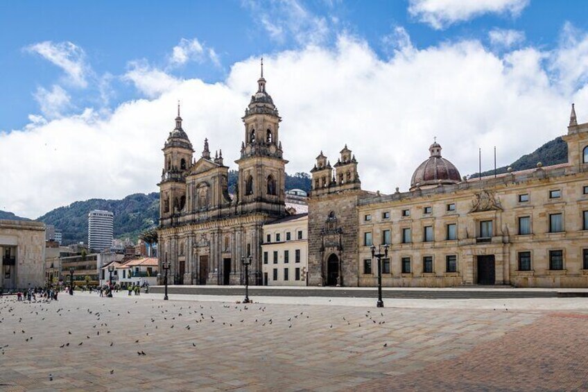A historic plaza with a prominent cathedral and a large dome, surrounded by buildings and mountains. 4