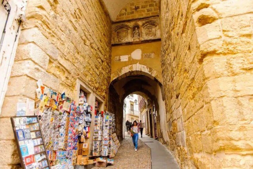 Un stretto vicolo in pietra con un negozio che vende cartoline e libri. 4
