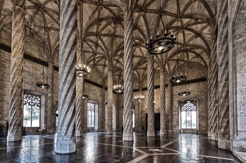 Un salón imponente con techos abovedados altos, grandes columnas y vidrieras elaboradas. 3
