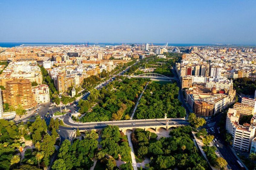 A cityscape with a prominent bridge, dense urban buildings, and a large green park area. 2