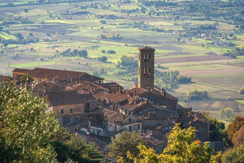 Un village doté d’un imposant beffroi, entouré de champs en terrasses et d’une végétation luxuriante. 3