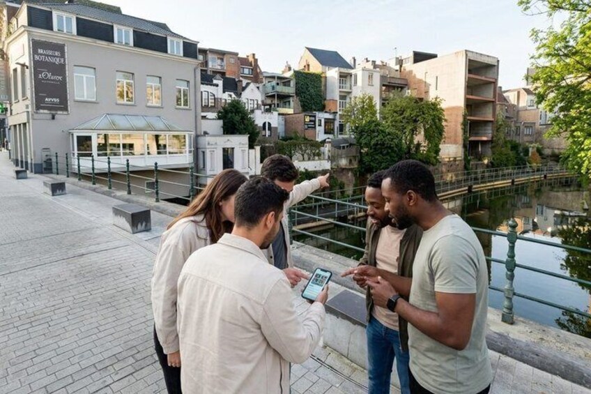 A group of people standing by a canal, looking at a map. 5