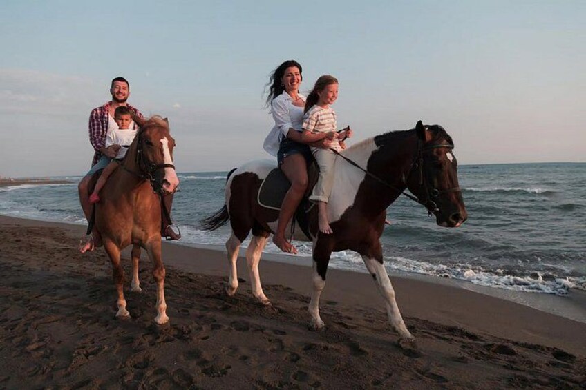Una playa con gente montando a caballo. 1