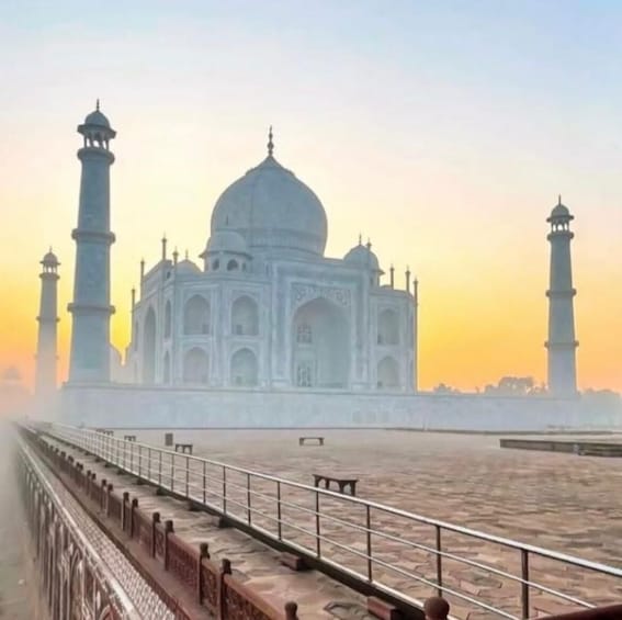 Taj Mahal med sina fyra minareter, en stor central kupol och en spegelbild i vattnet. 3