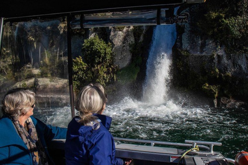 A boat with two people observing a waterfall. 4