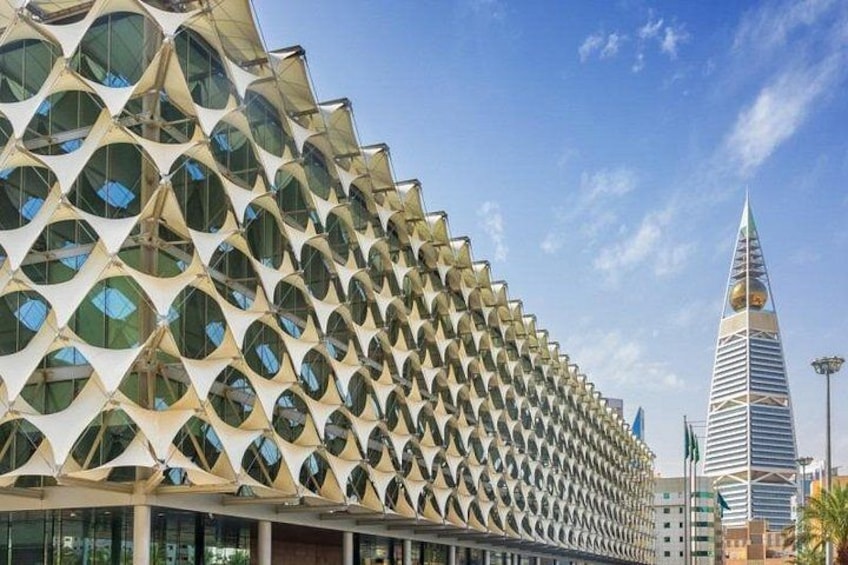 Un edificio moderno con una fachada geométrica distintiva y una aguja alta. 3