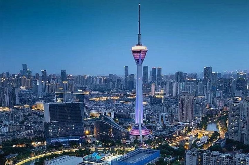 A cityscape with a prominent tower, dense urban buildings, and a river. 2