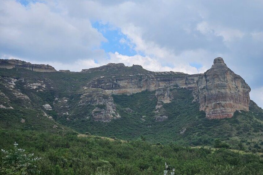 A mountainous landscape with green vegetation and rocky cliffs. 2