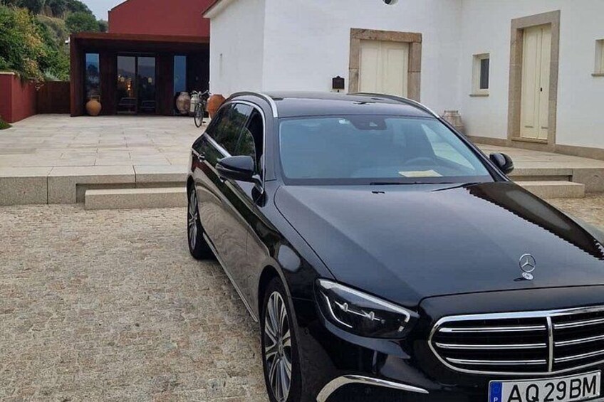 Un coche negro estacionado frente a un edificio con techo rojo y puertas color crema. 3