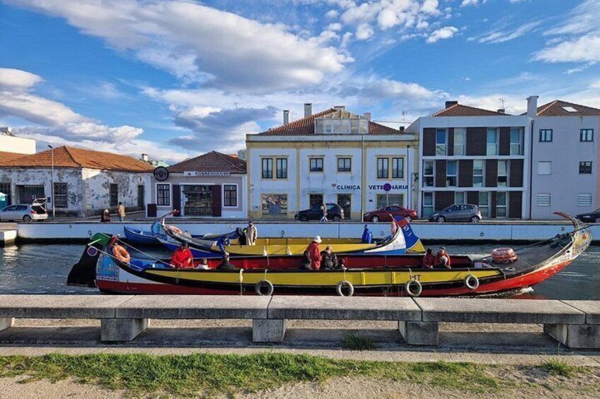 Un bote colorido amarrado en un muelle con edificios al fondo. 5