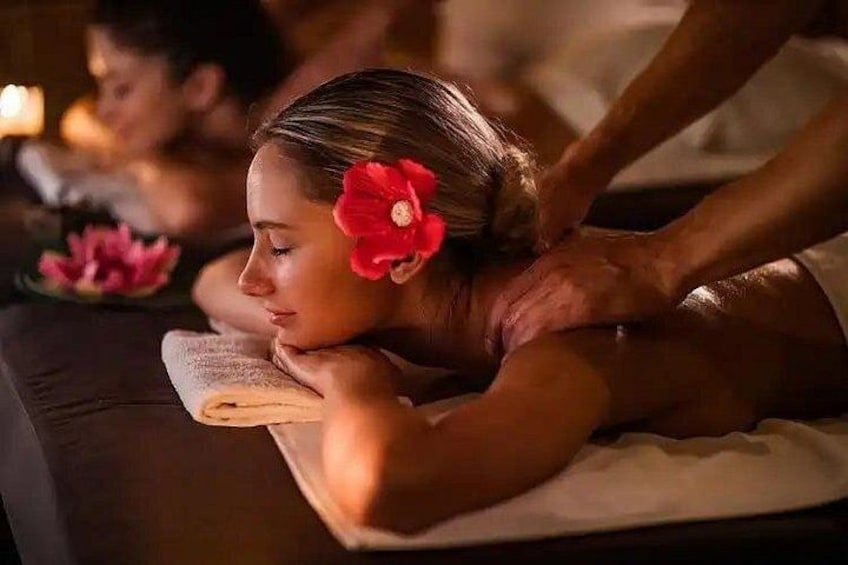 A person receiving a massage in a dimly lit room with candles. 1