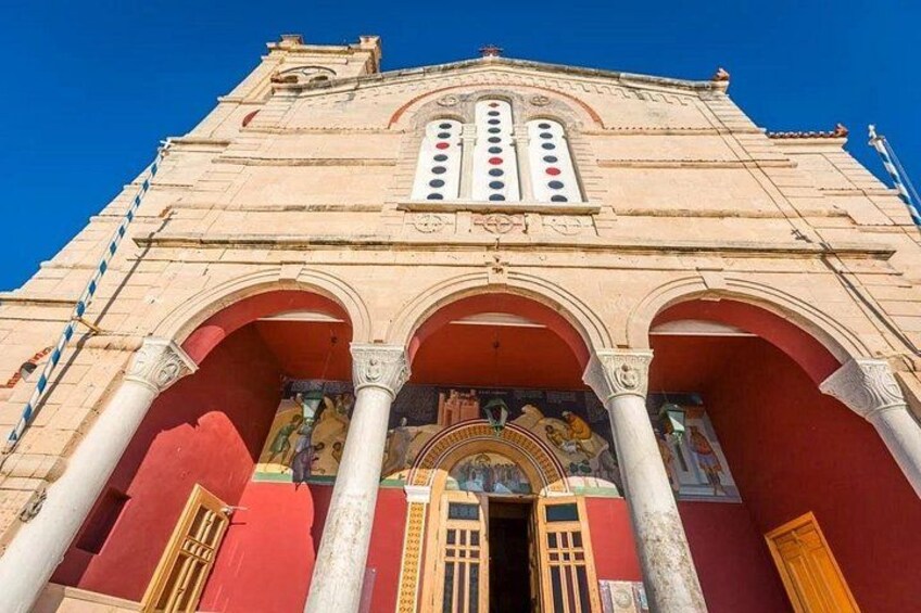 A large building with a red facade, multiple arches, and a central entrance. 3