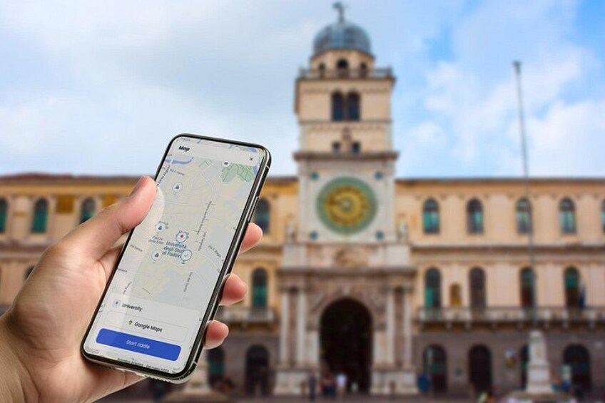 Una mano sosteniendo un teléfono inteligente que muestra un mapa con una torre del reloj al fondo. 1