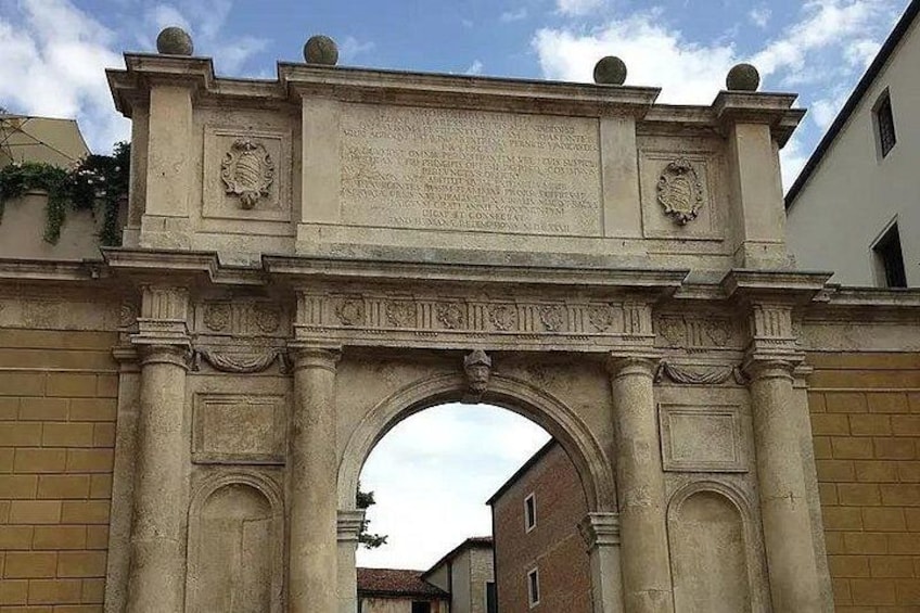 Un arco de piedra histórico con inscripciones y detalles decorativos. 4