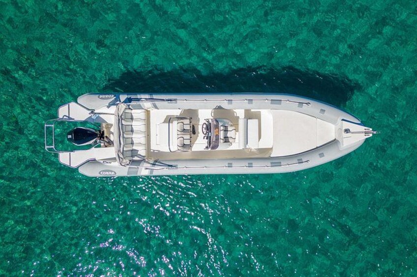 Vue aérienne d’un bateau à moteur blanc sur une eau turquoise et limpide. 3